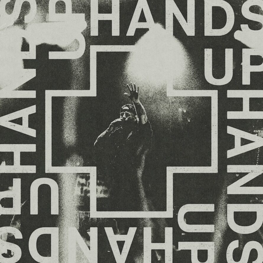 Cover artwork for Jelly Roll's single “Hands Up,” featuring a black-and-white live performance image framed by a cross with the title “Hands Up” surrounding it. Title: Jelly Roll – Hands Up Single Artwork Caption: Official artwork for Jelly Roll's single “Hands Up.” Description: Official single artwork for Jelly Roll's “Hands Up.” The black-and-white design features a live performance image of Jelly Roll inside a cross-shaped frame, with the words “Hands Up” displayed prominently around the artwork.